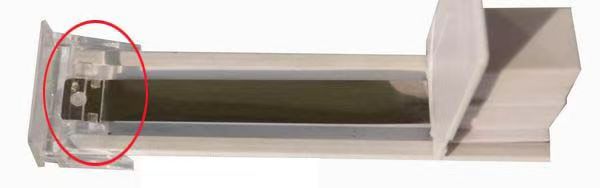A different shelf pusher mechanism with an upright end plate and a transparent end section marked by an original red circle.